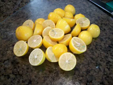 Limequat fruit cut in half on a bench.